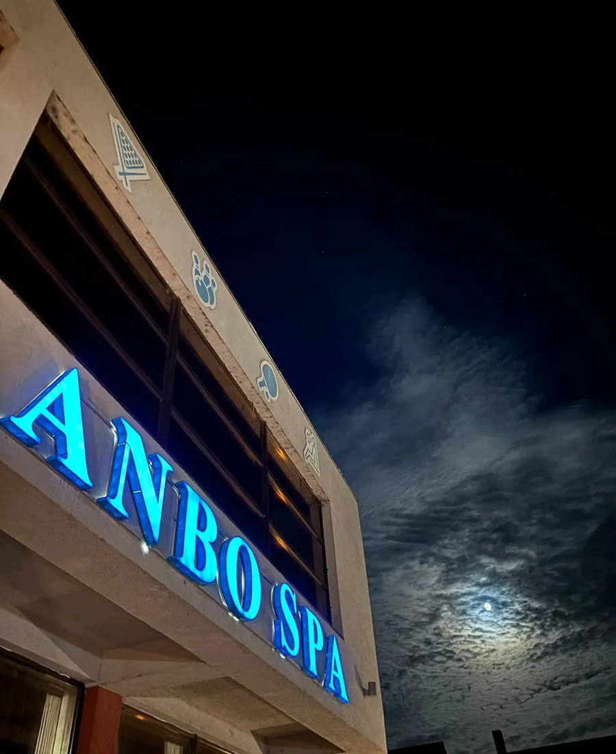 Literele luminoase Anbo Spa pe fațadă, noaptea, cu luna pe cer