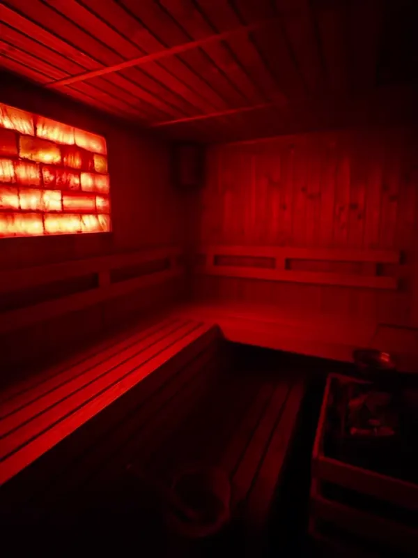 Sauna în lumină caldă, roșie, cu băncile de lemn
